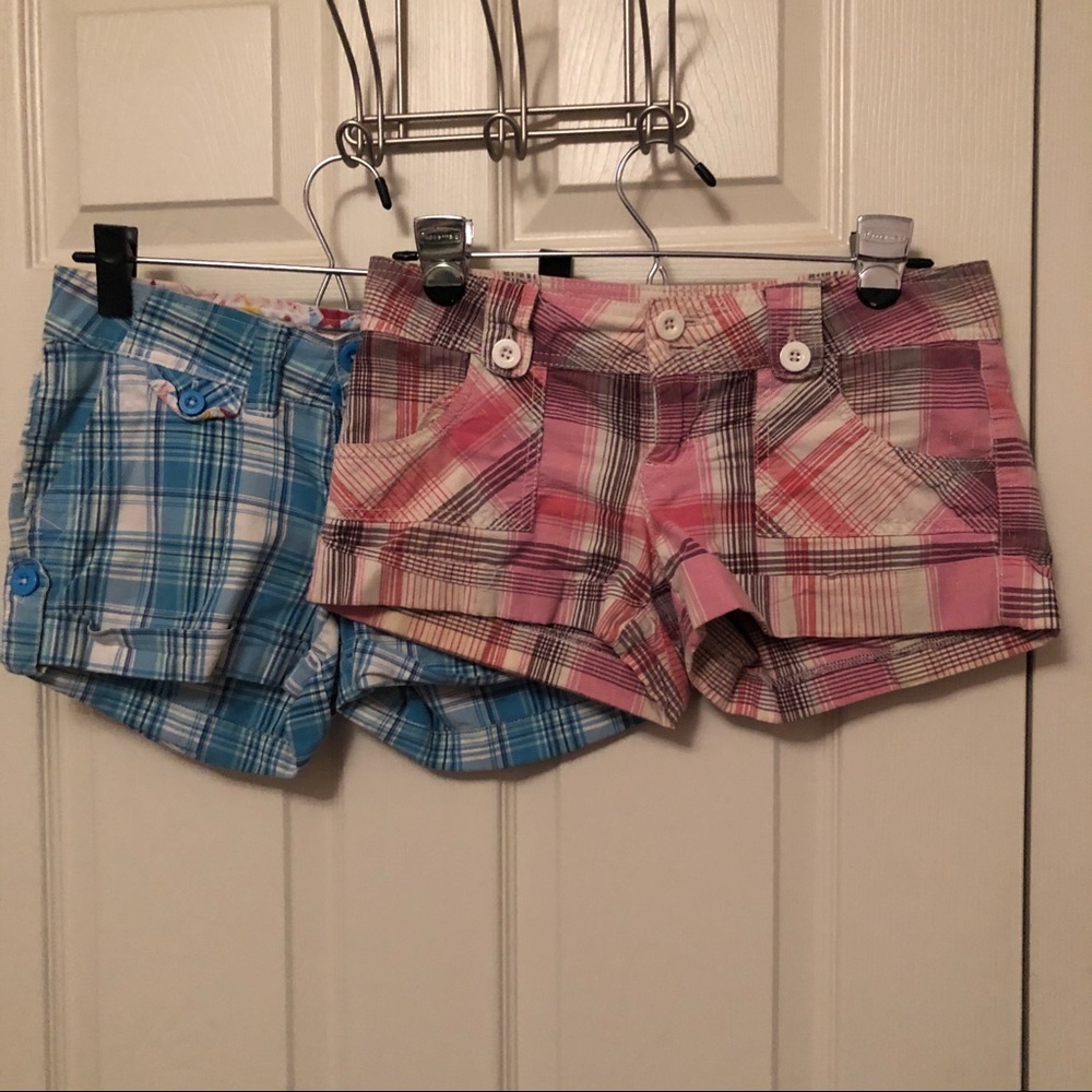 Two pairs of plaid shorts, blue and pink
